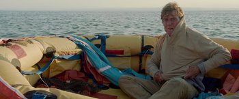Movie still from “All Is Lost” (2013), directed by J.C. Chandor – A man sitting on a boat in the water; Medium shot, High angle