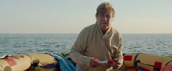 Movie still from “All Is Lost” (2013), directed by J.C. Chandor – An older man sitting on the back of a boat; Medium shot, Low angle