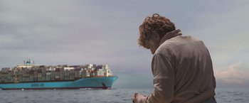 Movie still from “All Is Lost” (2013), directed by J.C. Chandor – A man standing in front of a large ship; Wide shot, Over the shoulder angle