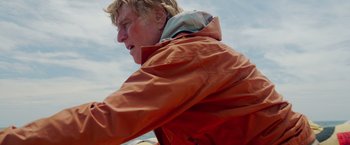 Movie still from “All Is Lost” (2013), directed by J.C. Chandor – A man in a red jacket is looking at the sky; Close Up shot, Low angle
