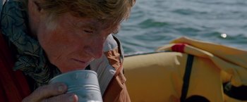 Movie still from “All Is Lost” (2013), directed by J.C. Chandor – A man is drinking water from a water bottle; Close Up shot, Low angle