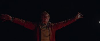 Movie still from “All Is Lost” (2013), directed by J.C. Chandor – An older woman in a red jacket is raising her arms; Medium shot, Low angle