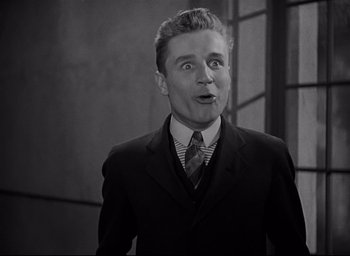 Movie still from “All Quiet on the Western Front” (1930), directed by Lewis Milestone – A man wearing a suit and tie standing in front of a wall; Close Up shot, Low angle