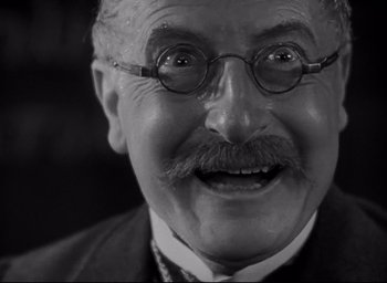 Movie still from “All Quiet on the Western Front” (1930), directed by Lewis Milestone – An older man with a mustache and glasses; Close Up shot, Low angle