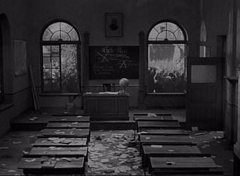 Movie still from “All Quiet on the Western Front” (1930), directed by Lewis Milestone – A classroom with desks and a chalkboard and many windows; Wide shot, High angle