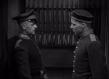 Movie still from “All Quiet on the Western Front” (1930), directed by Lewis Milestone – A couple of men standing next to each other; Medium shot, Low angle