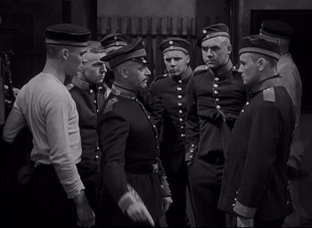 Movie still from “All Quiet on the Western Front” (1930), directed by Lewis Milestone – A black and white photo of a group of men in uniform; Medium shot, High angle