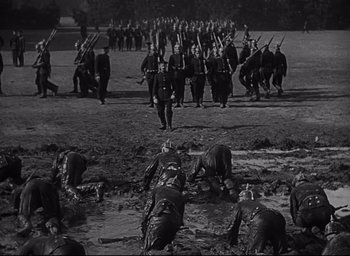 Movie still from “All Quiet on the Western Front” (1930), directed by Lewis Milestone – A black and white photo of a group of people in the mud; Extreme Wide shot, High angle