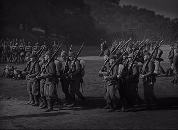 Movie still from “All Quiet on the Western Front” (1930), directed by Lewis Milestone – A group of men are standing together holding guns; Wide shot, High angle