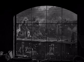 Movie still from “All Quiet on the Western Front” (1930), directed by Lewis Milestone – A black - and - white photo of a town with a lot of smoke coming out of the windows; Extreme Wide shot, High angle