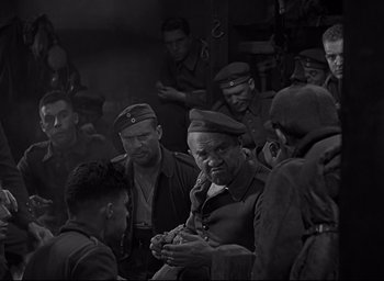 Movie still from “All Quiet on the Western Front” (1930), directed by Lewis Milestone – Black and white photograph of a group of men in uniform; Medium shot, High angle