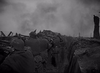 Movie still from “All Quiet on the Western Front” (1930), directed by Lewis Milestone – A black and white photo of a group of soldiers in a trench; Medium shot, High angle