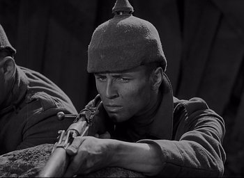 Movie still from “All Quiet on the Western Front” (1930), directed by Lewis Milestone – Black and white photograph of a man with a rifle; Close Up shot, High angle