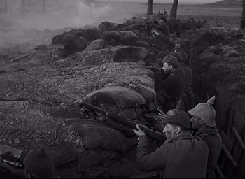 Movie still from “All Quiet on the Western Front” (1930), directed by Lewis Milestone – A black and white photo of a group of men standing in a field; Wide shot, Low angle