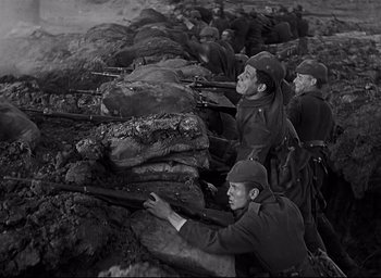 Movie still from “All Quiet on the Western Front” (1930), directed by Lewis Milestone – A black and white photo of men with rifles; Medium shot, Low angle