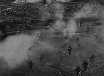 Movie still from “All Quiet on the Western Front” (1930), directed by Lewis Milestone – A black and white photo of a group of people walking through a field; Extreme Wide shot, High angle