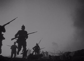 Movie still from “All Quiet on the Western Front” (1930), directed by Lewis Milestone – A black and white photo of a group of men holding guns; Wide shot, Low angle
