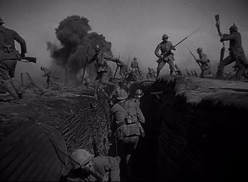 Movie still from “All Quiet on the Western Front” (1930), directed by Lewis Milestone – A black and white photo of a group of soldiers in a trench; Wide shot, Low angle
