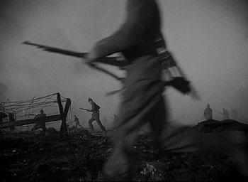 Movie still from “All Quiet on the Western Front” (1930), directed by Lewis Milestone – A black and white photo of a group of people walking through a field; Wide shot, Low angle