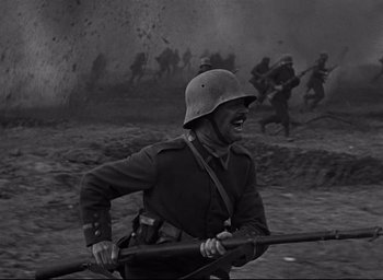 Movie still from “All Quiet on the Western Front” (1930), directed by Lewis Milestone – An old photo of a man holding a rifle in a field; Medium shot, Low angle