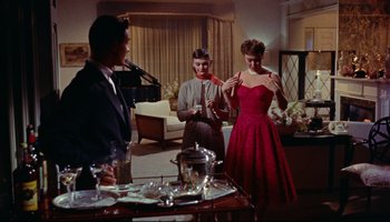 Movie still from “All That Heaven Allows” (1955), directed by Douglas Sirk – A group of people standing in a living room; Wide shot, Low angle