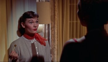 Movie still from “All That Heaven Allows” (1955), directed by Douglas Sirk – A woman wearing a red neck scarf looking into a mirror; Close Up shot, Over the shoulder angle