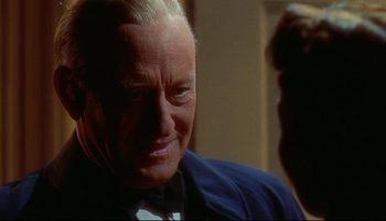 Movie still from “All That Heaven Allows” (1955), directed by Douglas Sirk – An older man in a suit and tie smiling for the camera; Close Up shot, Over the shoulder angle