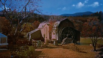 Movie still from “All That Heaven Allows” (1955), directed by Douglas Sirk – An old barn with a water wheel in the middle of it; Extreme Wide shot, High angle