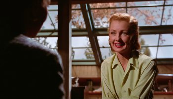 Movie still from “All That Heaven Allows” (1955), directed by Douglas Sirk – A woman in a yellow shirt smiling at a man in a yellow shirt; Medium shot, Over the shoulder angle