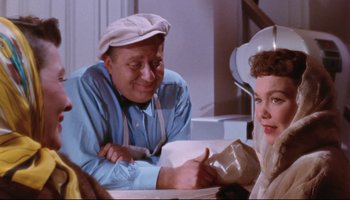 Movie still from “All That Heaven Allows” (1955), directed by Douglas Sirk – An older man and a young woman sitting at a table; Medium shot, Over the shoulder angle