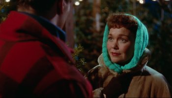 Movie still from “All That Heaven Allows” (1955), directed by Douglas Sirk – A woman wearing a fur coat and a blue hat; Close Up shot, Over the shoulder angle