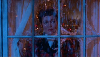 Movie still from “All That Heaven Allows” (1955), directed by Douglas Sirk – A woman looking out of a window at christmas; Medium shot, Low angle