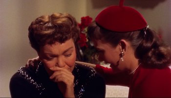 Movie still from “All That Heaven Allows” (1955), directed by Douglas Sirk – Two women are sitting and one of them is touching her face; Close Up shot, High angle