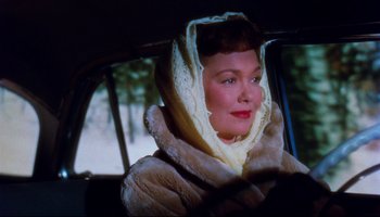 Movie still from “All That Heaven Allows” (1955), directed by Douglas Sirk – A woman in a fur coat and a scarf in a car; Close Up shot, Low angle