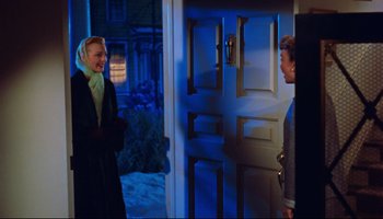 Movie still from “All That Heaven Allows” (1955), directed by Douglas Sirk – Two people standing in front of an open front door; Medium shot, Over the shoulder angle