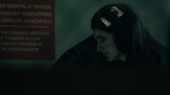 Movie still from “Snowfall” (2017), directed by Hiro Murai – A woman sitting in a dark room with her head turned to the side; Close Up shot, Over the shoulder angle