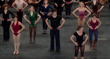 Movie still from “All That Jazz” (1979), directed by Bob Fosse – A group of people standing in a room with their hands on their hips; Wide shot, High angle