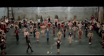 Movie still from “All That Jazz” (1979), directed by Bob Fosse – A group of people standing on top of a stage; Wide shot, High angle