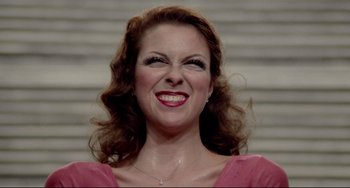 Movie still from “All That Jazz” (1979), directed by Bob Fosse – A person smiling with her mouth open; Close Up shot, Overhead angle