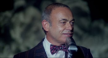 Movie still from “All That Jazz” (1979), directed by Bob Fosse – A person wearing a suit and bow tie; Close Up shot, Low angle