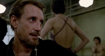 Movie still from “All That Jazz” (1979), directed by Bob Fosse – A person smoking a cigarette in a room; Close Up shot, Over the shoulder angle