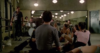 Movie still from “All That Jazz” (1979), directed by Bob Fosse – A group of people sitting in a room with lights above them; Wide shot, High angle