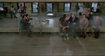 Movie still from “All That Jazz” (1979), directed by Bob Fosse – A group of people sitting around a table; Wide shot, Over the shoulder angle