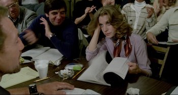 Movie still from “All That Jazz” (1979), directed by Bob Fosse – A woman sitting at a wooden table with a man; Medium shot, Over the shoulder angle