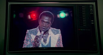 Movie still from “All That Jazz” (1979), directed by Bob Fosse – A person holding a microphone on a tv screen; Close Up shot, Over the shoulder angle