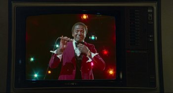 Movie still from “All That Jazz” (1979), directed by Bob Fosse – A person on a television screen; Medium shot, Low angle