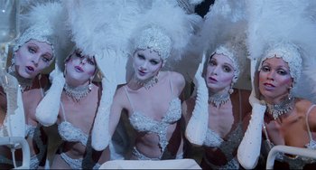 Movie still from “All That Jazz” (1979), directed by Bob Fosse – A group of women in white costumes with white feathers; Medium shot, Low angle