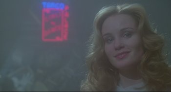 Movie still from “All That Jazz” (1979), directed by Bob Fosse – A woman with long blonde hair standing in front of a neon sign; Close Up shot, Low angle