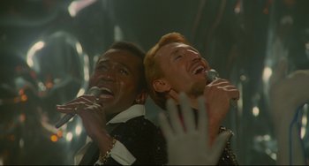Movie still from “All That Jazz” (1979), directed by Bob Fosse – A couple of men singing into microphones in a room; Close Up shot, High angle