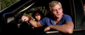 Movie still from “All the Boys Love Mandy Lane” (2006), directed by Jonathan Levine – Two young men driving in a car on the road; Close Up shot, Low angle